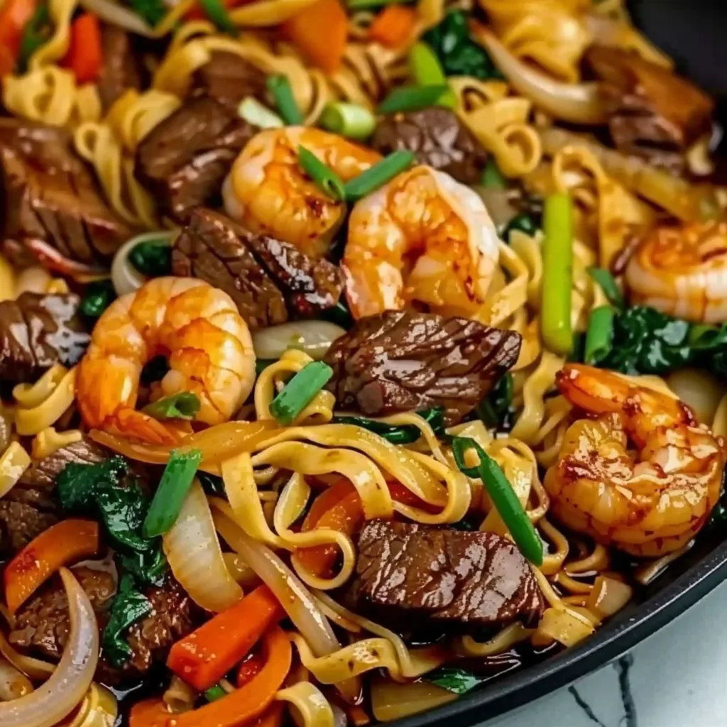 A bowl of noodles with shrimp and vegetables.