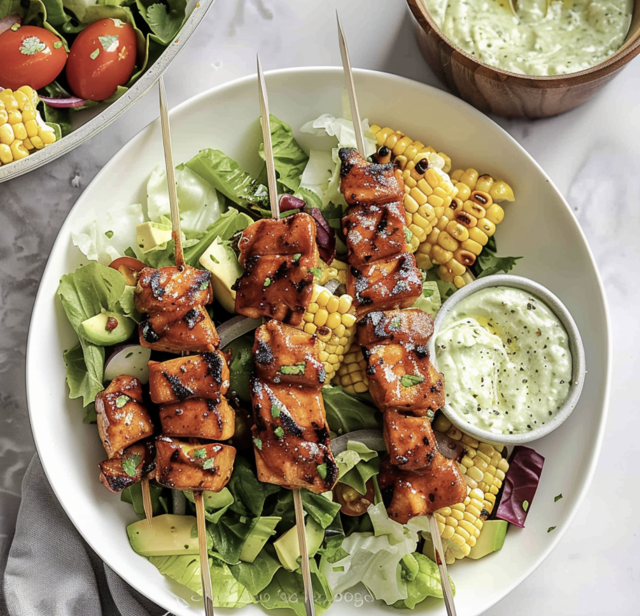 A plate of food with chicken skewers and salad.