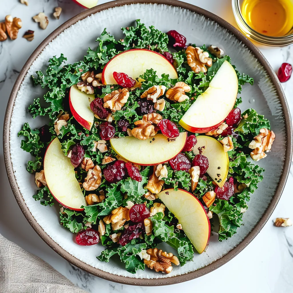 A bowl of salad with apples, walnuts, and kale.