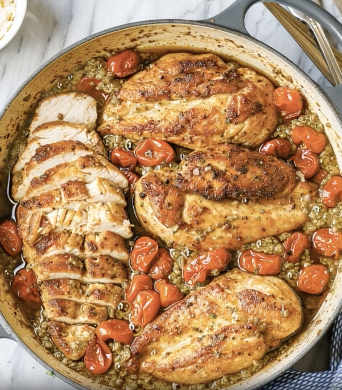 A pot of food with chicken and tomatoes.