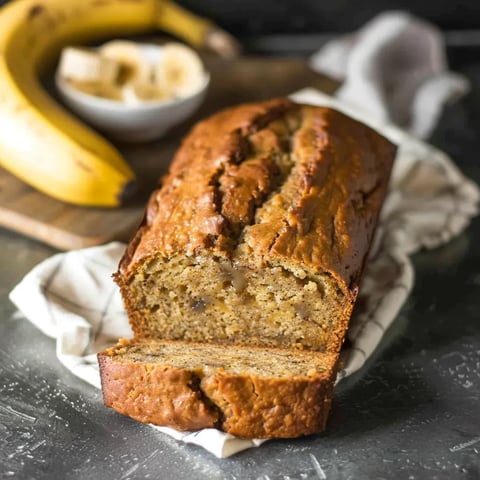 A loaf of banana bread with a slice missing.
